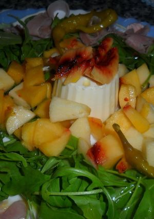Una foto de Ensalada de rúcula con jamón, queso y frutas 