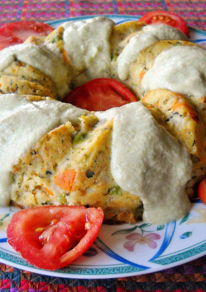Una foto de Pastel de merluza con salsa de judías verdes y queso