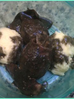 Una foto de Puré de patatas bañado con chipirones en tinta