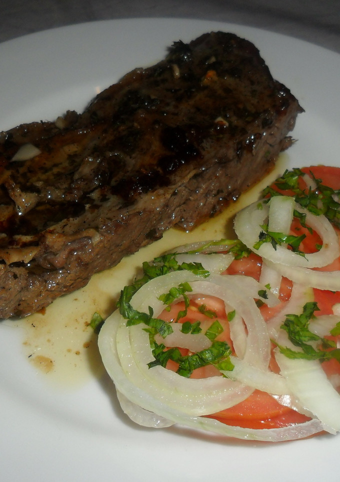 Una foto de Vacío asado al chimichurri con ensalada de tomates