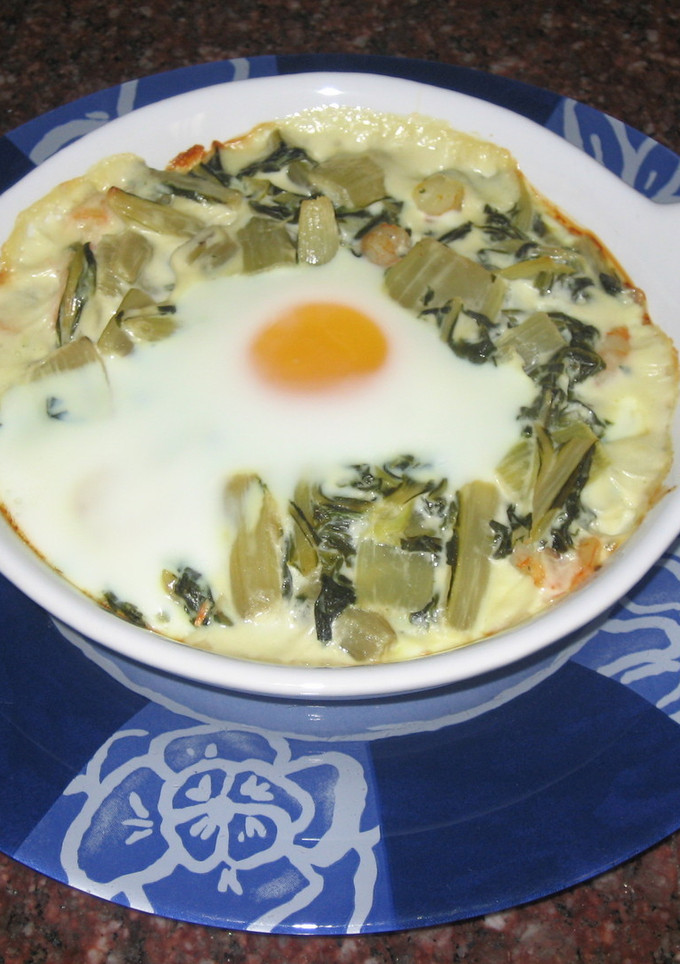 Una foto de Huevos al plato con ajos tiernos, gambas y nata