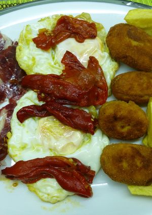 Una foto de Plato combinado de huevos fritos con jamón y croquetas de boletus