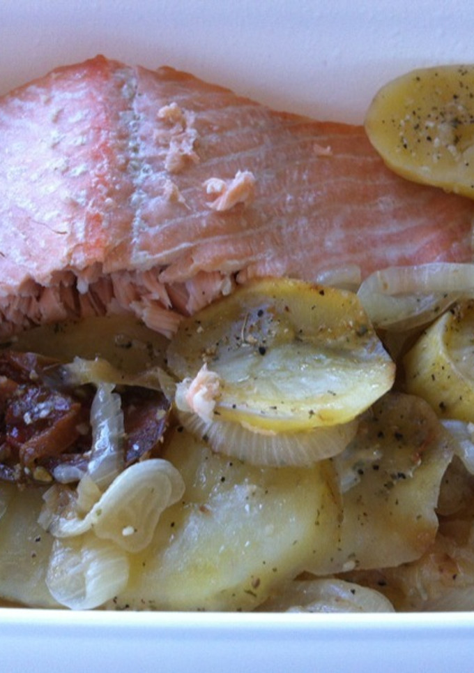 Una foto de Salmón al horno con cebolla, patatas y tomate