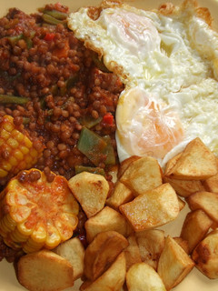 Una foto de Plato de lentejas, patatas y huevos fritos con choclo (mazorca de maíz)