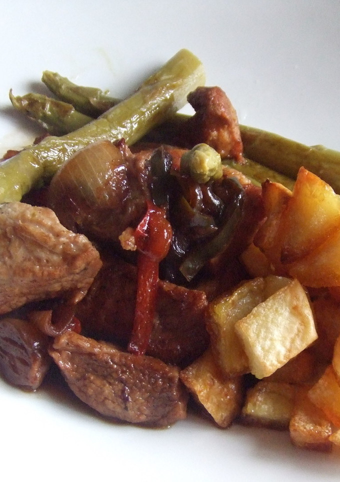 Una foto de Secreto ibérico con cebollitas francesas y dados de patatas