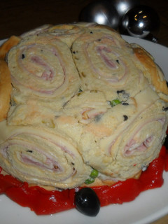 Una foto de Tarta de ensalada rusa y rollitos de pionono con jamón y queso