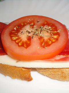 Una foto de Pintxo de jamón serrano con queso y tomate