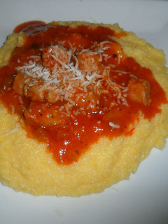 Una foto de Polenta con queso cremoso y salchichas en salsa de tomate