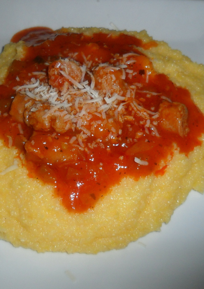 Una foto de Polenta con queso cremoso y salchichas en salsa de tomate