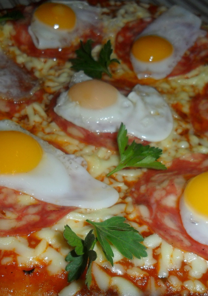 Una foto de Pizza con salame y huevos de codorniz