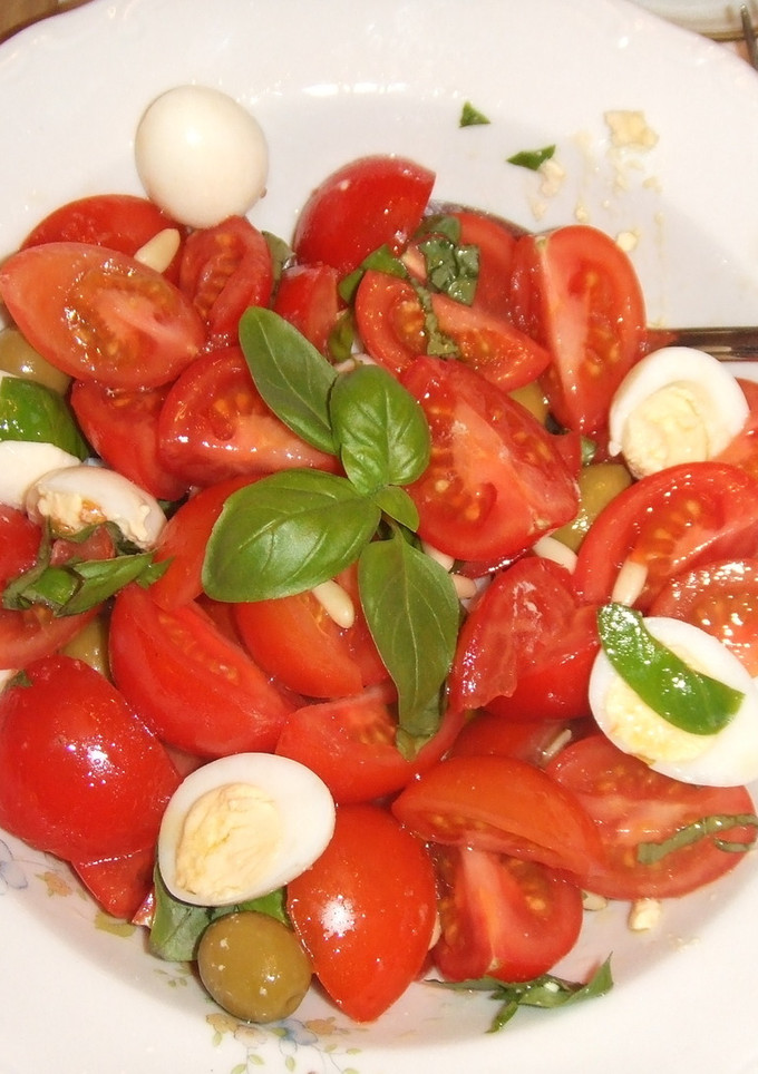 Una foto de Ensalada sencilla de tomates, piñones y albahaca con huevos de codorniz
