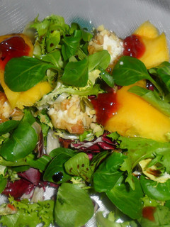 Una foto de Ensalada de lechugas variadas con queso de cabra y mango