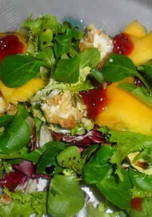Una foto de Ensalada de lechugas variadas con queso de cabra y mango