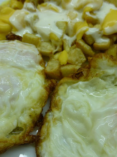 Una foto de Patatas fritas con salsa de yogur y huevos fritos