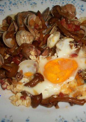 Una foto de Cazuela de setas y almejas con huevos escalfados