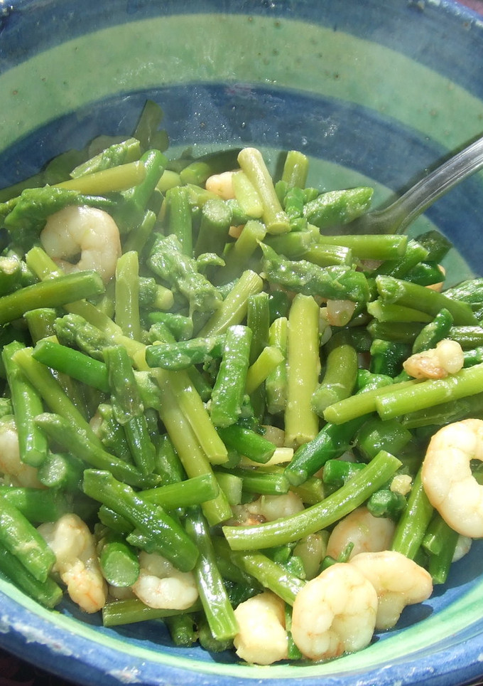 Una foto de Salteado de primavera con guisantes, espárragos y gambas