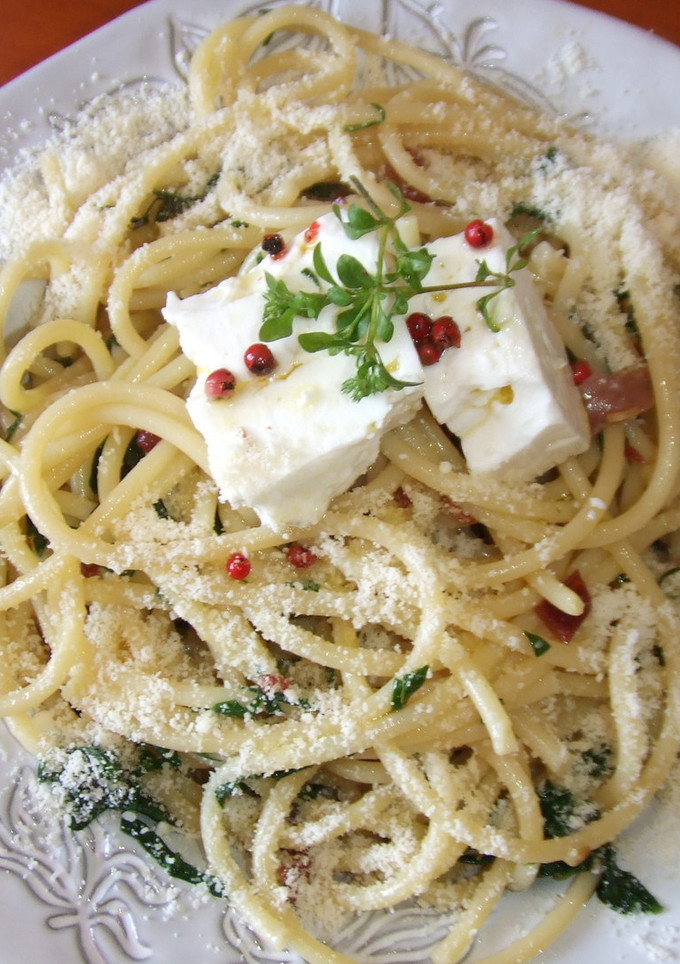 Una foto de Bucatini con queso feta marinado en aceite de oliva y pimienta rosa