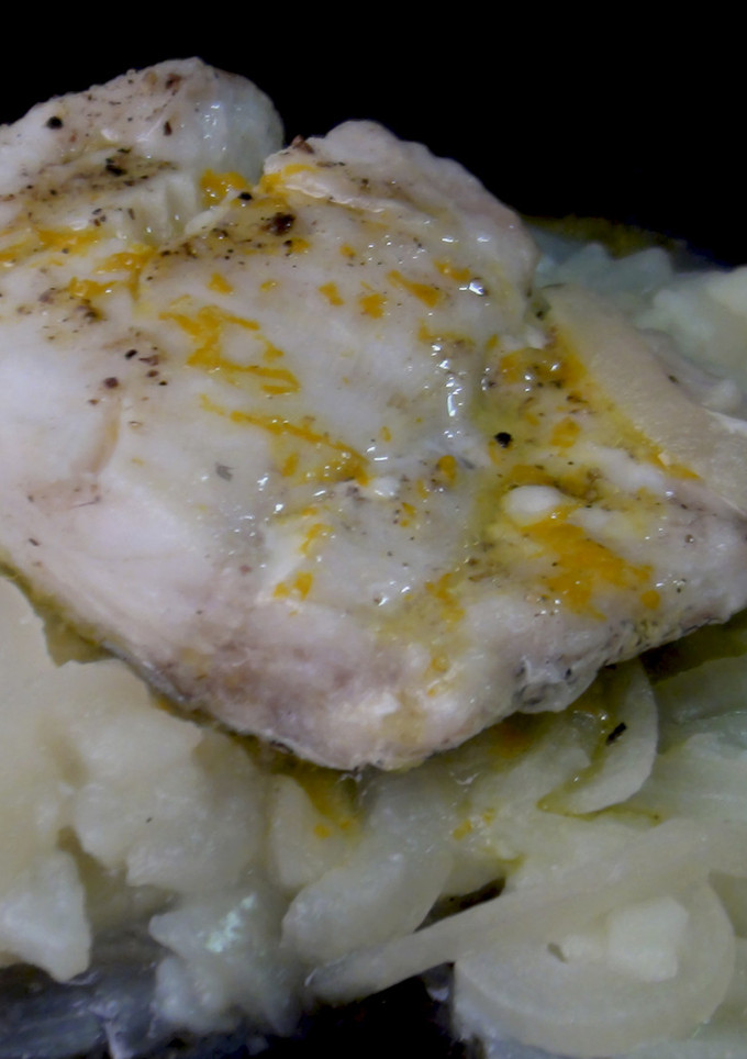 Una foto de Merluza con papas, cebolla y salsa de naranja