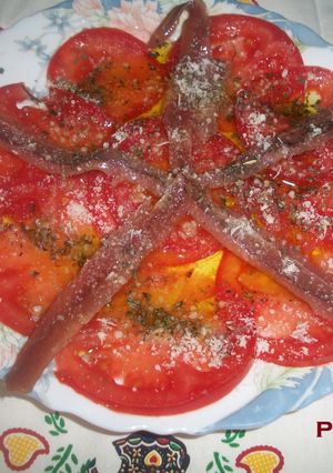 Una foto de Carpaccio de tomate y anchoas al parmesano