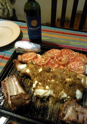 Una foto de Asado a la parrilla de matambre de cerdo pizzaiola al ajillo