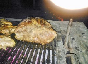Una foto de Asado a la parrilla de bondiola de cerdo rellena de vegetales