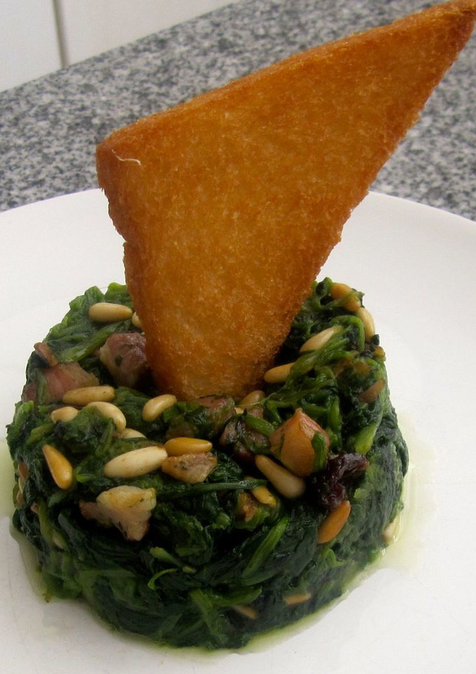 Una foto de Espinacas con bacon, piñones y pasas