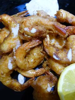 Una foto de Langostinos en tempura con salsa