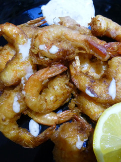 Una foto de Langostinos en tempura con salsa