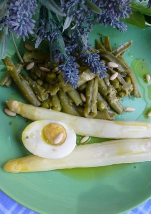 Una foto de Habitas y guisantes con espárragos y huevo