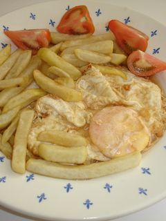 Una foto de Huevo frito con mantequilla, patatas fritas y tomate