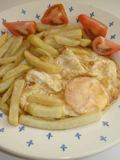 Una foto de Huevo frito con mantequilla, patatas fritas y tomate