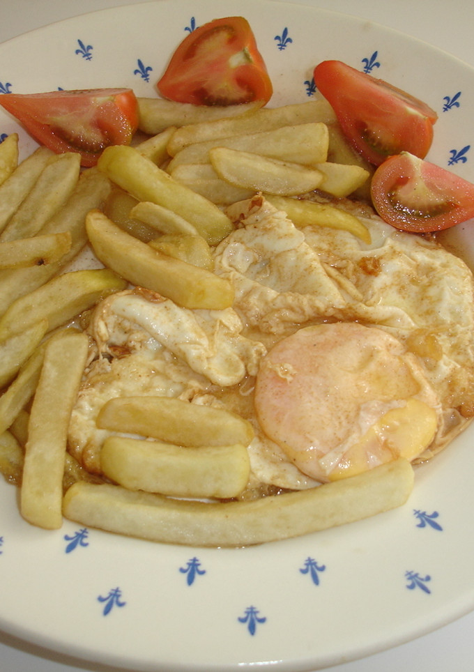 Una foto de Huevo frito con mantequilla, patatas fritas y tomate