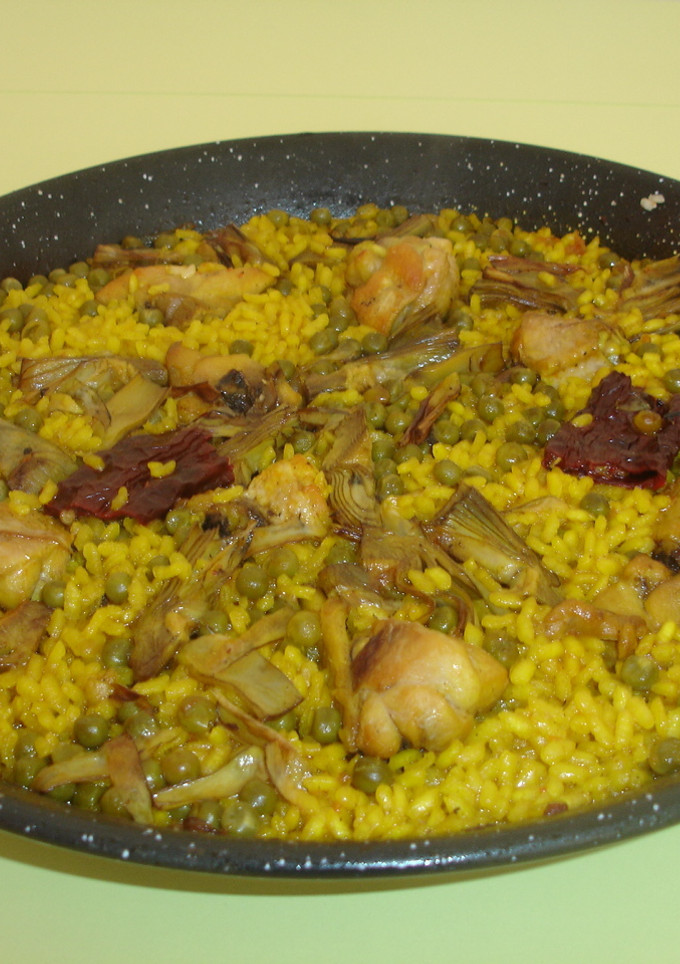 Una foto de Paella de pollo, alcachofas y guisantes
