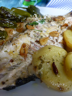 Una foto de Sargo al horno con patatas y pimientos del padrón