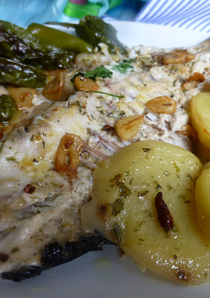 Una foto de Sargo al horno con patatas y pimientos del padrón