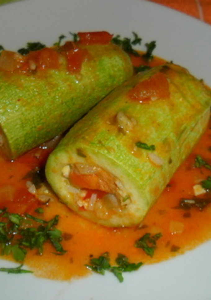 Una foto de Calabacines rellenos de arroz y verduras en salsa de tomate