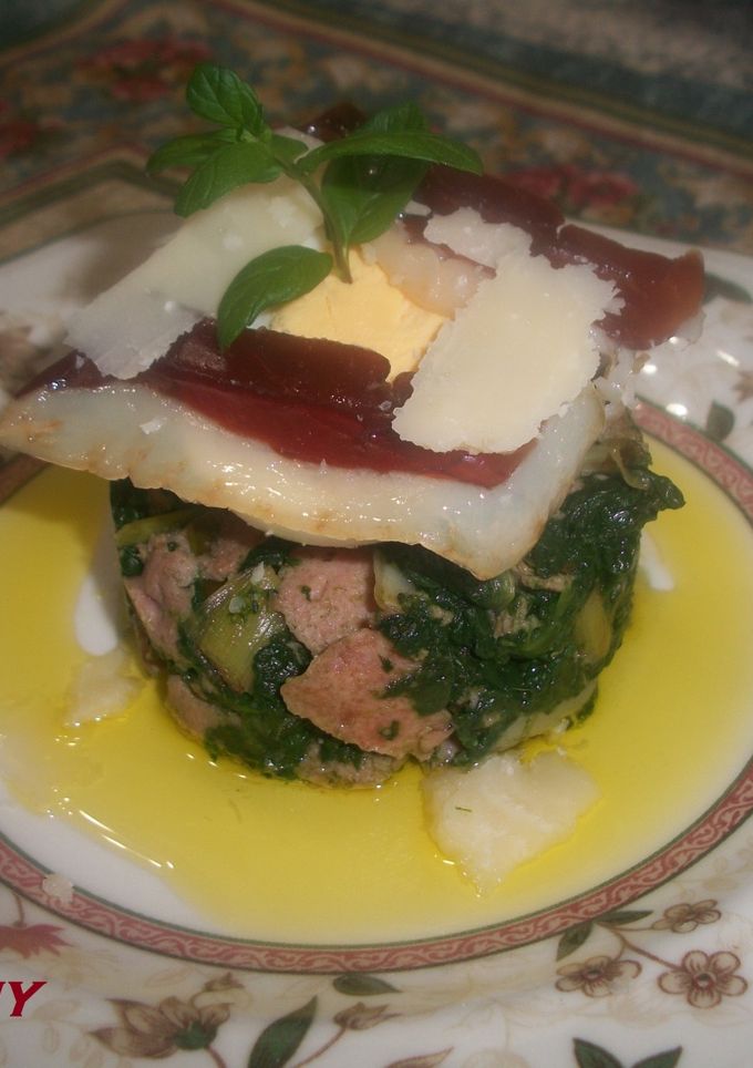 Una foto de Timbal de espinacas con jamón de pato y lascas de parmesano
