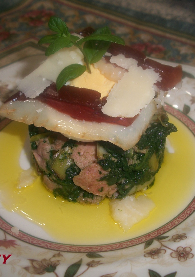Una foto de Timbal de espinacas con jamón de pato y lascas de parmesano