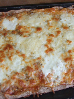 Una foto de Pizza integral cuadrada con cebolla y quesos variados