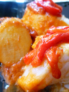 Una foto de Bacalao con tomate, patatas y pimientos rojos