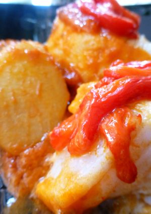 Una foto de Bacalao con tomate, patatas y pimientos rojos