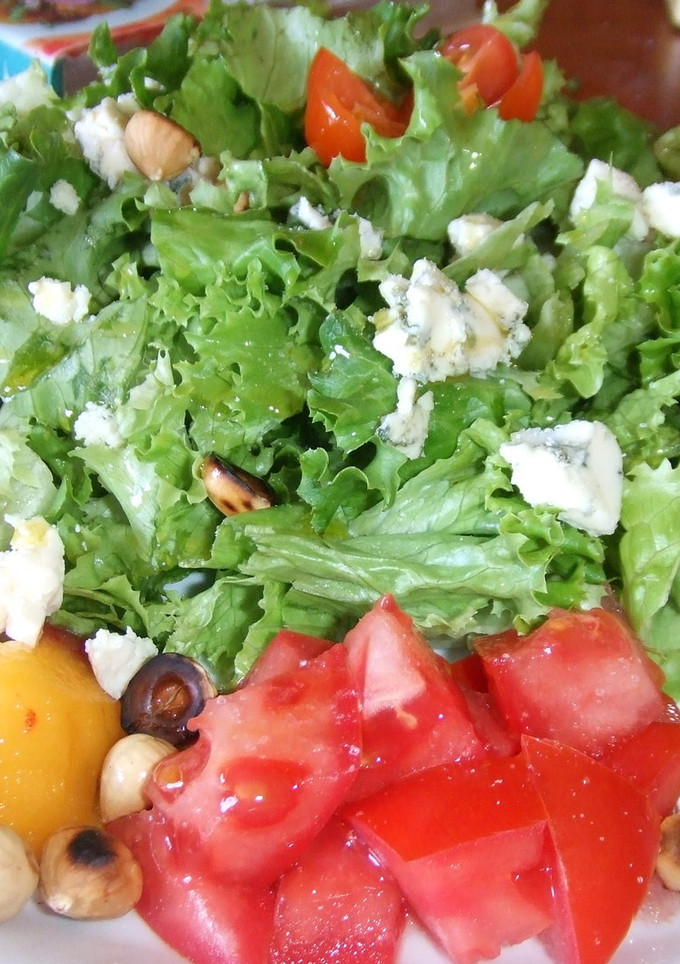 Una foto de Ensalada de lechuga rizada con frutas, queso azul y avellanas