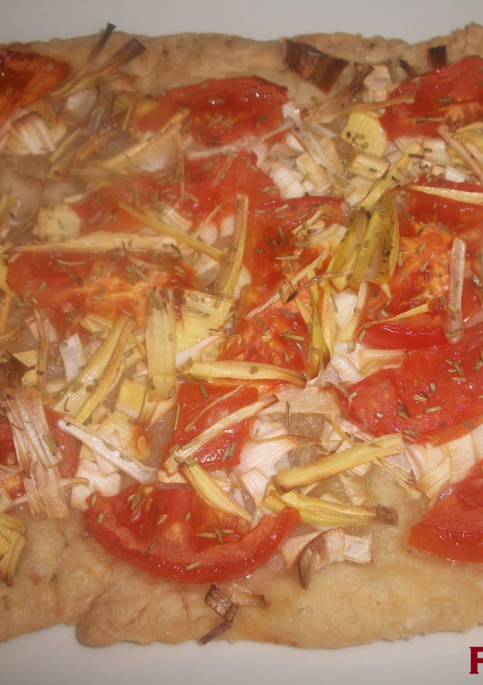Una foto de Coca de puerros con tomate al romero