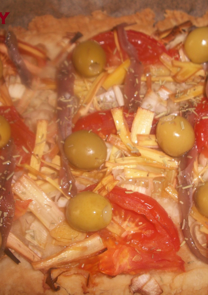 Una foto de Coca de verduras con anchoas y aceitunas