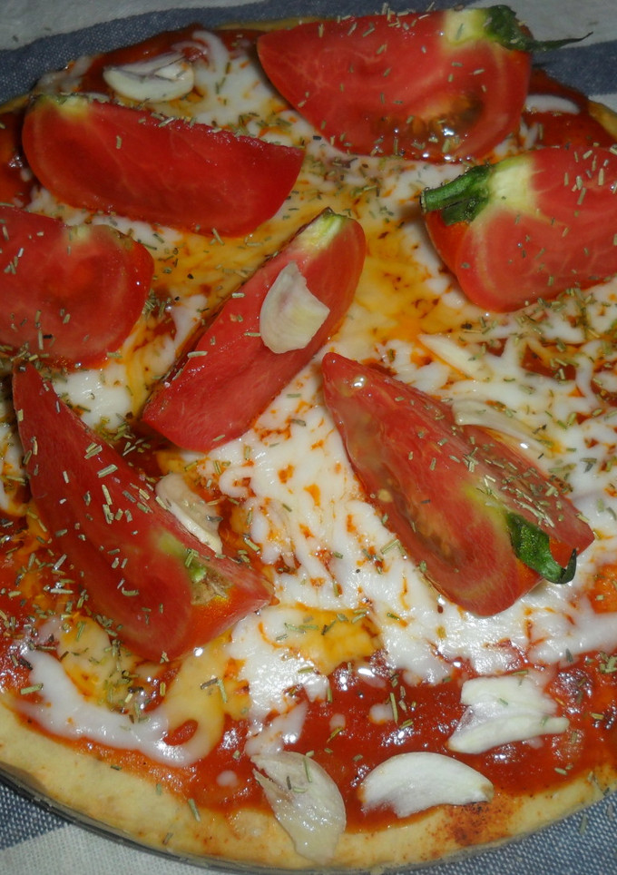 Una foto de Pizza al ajo con tomates frescos
