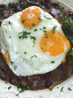 Una foto de Judías rojas con huevos a la plancha y pimientos de Padrón