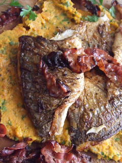 Una foto de Pescado crujiente en tabla con puré de boniatos