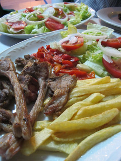 Una foto de Chuleta de cordero con patatas fritas y ensalada