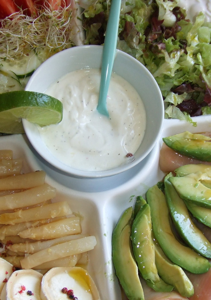 Una foto de Ensalada de salmón con aguacate, brotes de alfalfa y salsa de yogur
