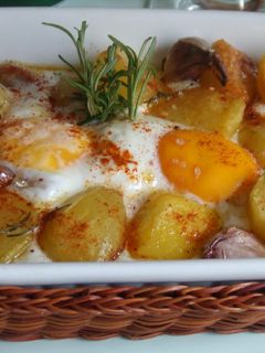 Una foto de Patatas horneadas con huevos y ajos